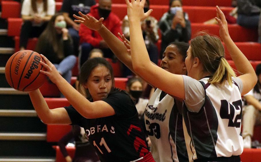 E.J. King's Mali Schinker is hemmed in by Matthew C. Perry's Breaunna Hayes and Isabella Hewitt during Friday's DODEA-Japan basketball game. The Cobras won 49-13.