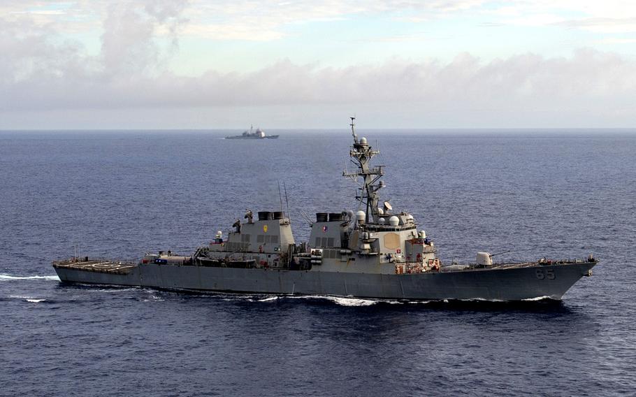 The guided-missile destroyer USS Benfold steams in formation with the aircraft carrier USS Ronald Reagan in the Philippine Sea on June 4, 2022. 