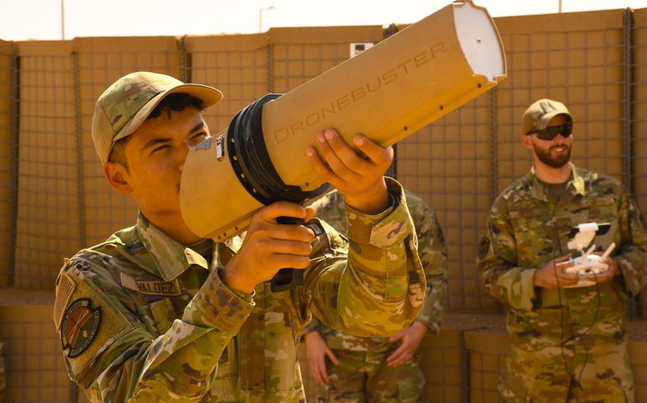 Airman 1st Class Phillip Valdez aims a Dronebuster jammer at an unmanned aircraft piloted by Staff Sgt. Harrison Hayes, right, during training at Prince Sultan Air Base in Saudi Arabia on June 9, 2023.