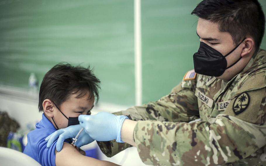 Jerrold Crisostomo, 9, of Inalajan, Guam, receives a pediatric dose of a COVID-19 vaccine from Army Pvt. 1st Class Jordan Suzuki at Merizo Elementary School, Jan. 27, 2022.