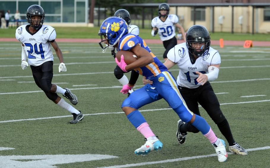 Yokota's Josef Brown turns upfield trying to elude Osan's Tim Davidson.