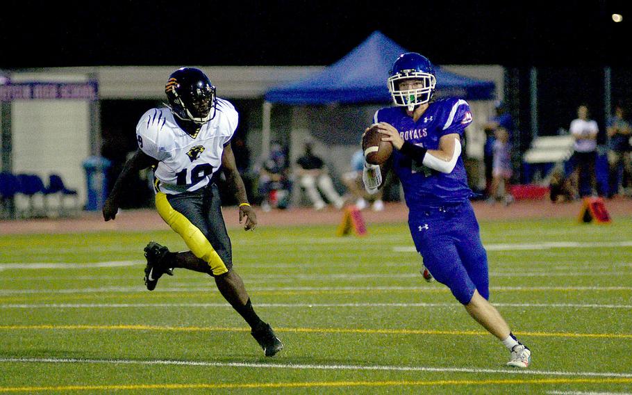 Ramstein quarterback Lucas Hollenbeck rolls out while trying to find a receiver during a Sept. 8, 2023, game against Stuttgart at Ramstein High School on Ramstein Air Base, Germany. Chasing is the Panthers' Nathan Clery.