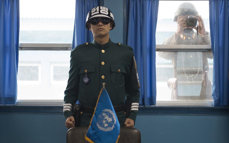 A South Korean soldier stands guard in the Joint Security Area of the Demilitarized Zone as a North Korean soldier snaps a photograph, Nov. 2, 2015. 