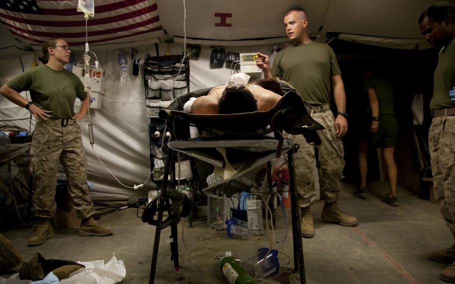 Medical personnel at Forward Operating Base Edinburgh in Helmand Province, shown here in June 2012, discuss the case of a patient. 