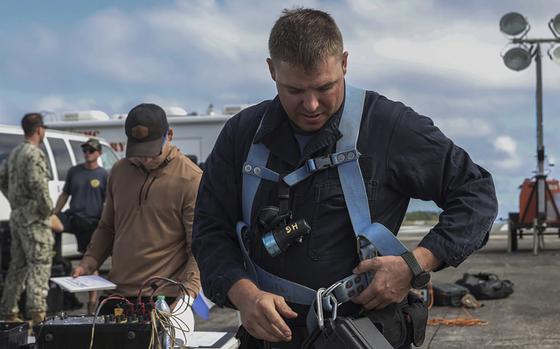This photo provided by U.S. Marine Corps,  A U.S. Navy Sailor with Company 1-3, Mobile Diving and Salvage Unit 1, prepares diving equipment to retrieve the aircraft flight recorder from a downed U.S. Navy P-8A Poseidon in waters just off the runway at Marine Corps Air Station Kaneohe Bay, Marine Corps Base Hawaii,  Thursday, Nov. 23, 2023.  The flight data recorder has been recovered as the military continues to plan for the aircraft’s removal.(Lance Cpl. Hunter Jones/U.S. Marine Corps via AP)