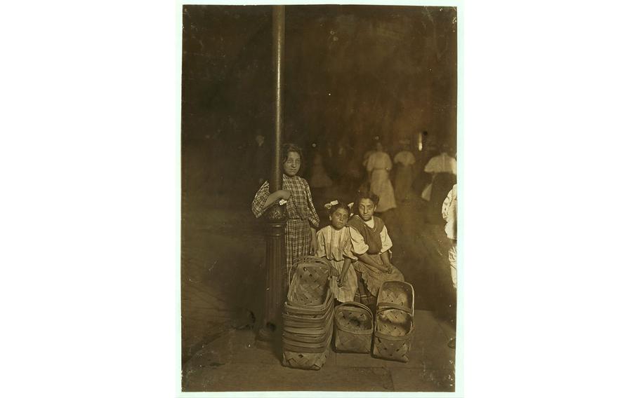 Marie Costa, left, had been selling baskets on the street for 11 hours when Lewis Hine photographed her at 9 p.m. with her sister and a friend in Cincinnati.