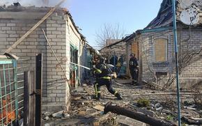 A firefighter sprays water into a destroyed building to put out a fire.