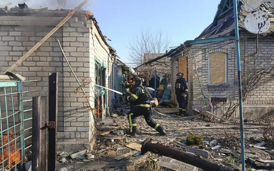 A firefighter sprays water into a destroyed building to put out a fire.