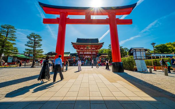 The morning sun peeks over the entrance to Fushimi Inari Shrine in Kyoto, Japan, May 28, 2025.