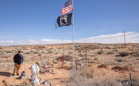Brandon Whiterock stands by the grave of his mother, Lori Piestewa, at the Hopi section of the Tuba City Cemetery in Arizona on Feb. 19. MUST CREDIT: Photo for The Washington Post by Caitlin O'Hara