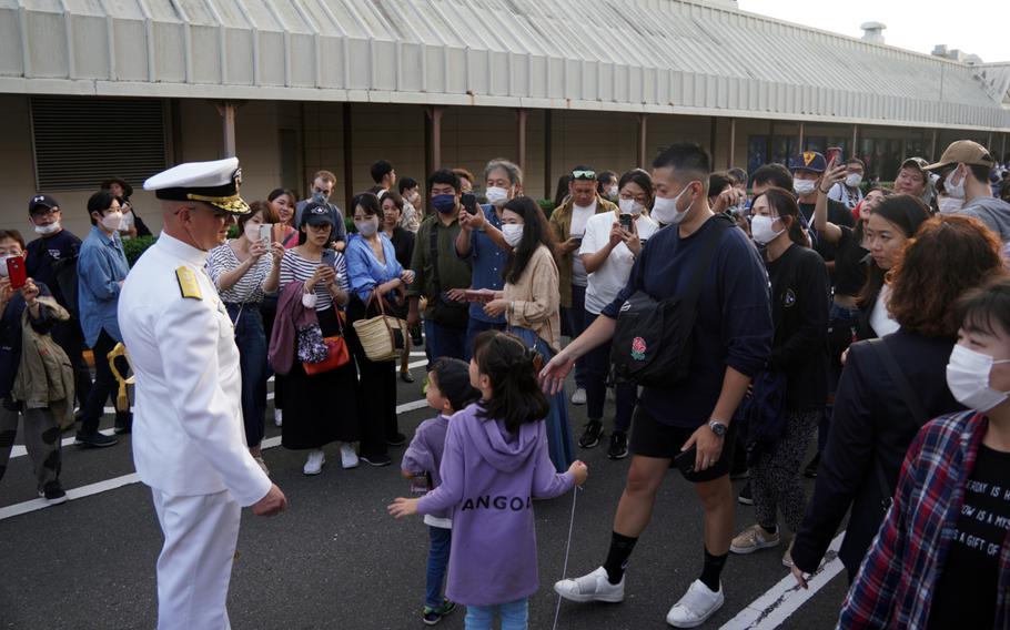 The commander of Navy Region Japan, Rear Adm. Carl Lahti, poses for photos during Friendship Day at Yokosuka Naval Base, Japan, Sunday, Oct. 16, 2022. 
