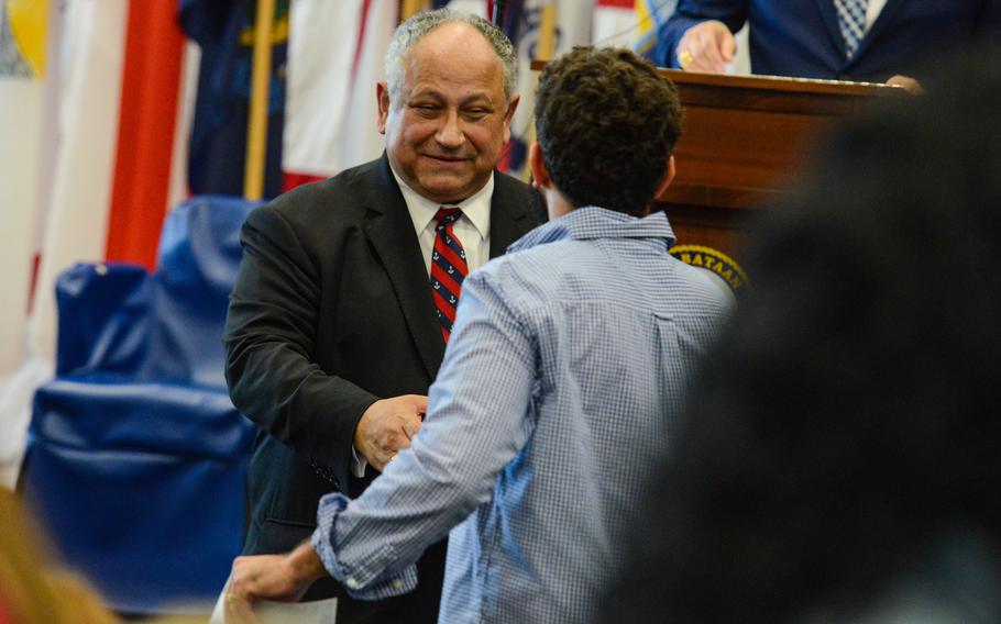 Navy Secretary Carlos Del Toro congratulates a new American citizen during a naturalization ceremony Tuesday, May 7, 2024, aboard the USS Bataan. The Navy hosted the ceremony aboard the amphibious assault ship docked in the port of Miami during the city’s Fleet Week. 