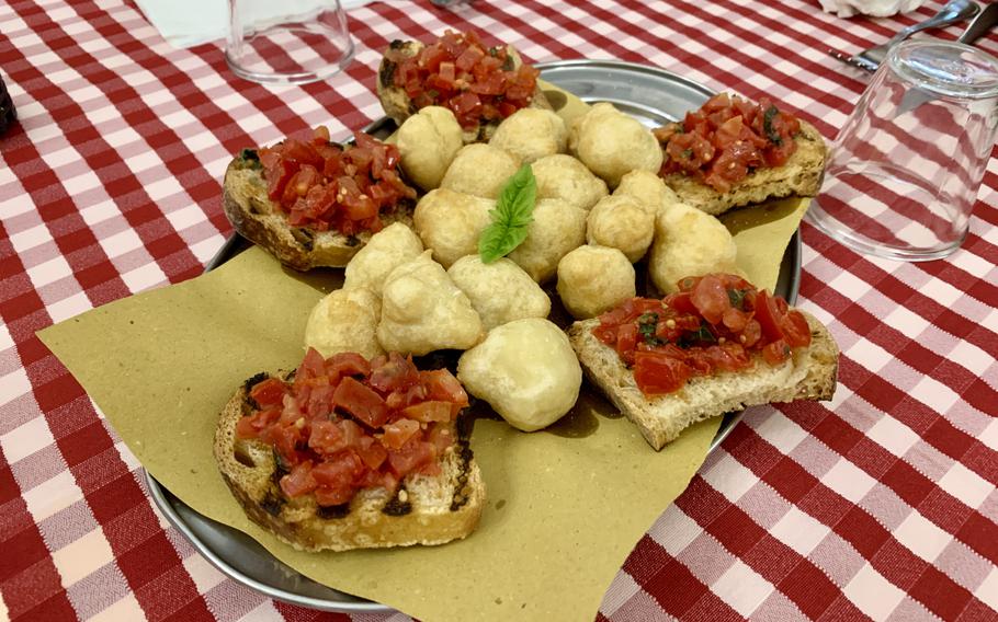 Bruschetta and fried dough balls on a red and white checkered table