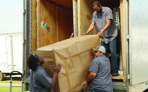 Workers from River City Movers conduct a direct delivery May 9 for Staff Sgt. Cornel Varnado Jr., 194th Military Police Company, 716th Military Police Battalion, at Fort Campbell whose belongings were transported overseas from his previous duty station in Germany during a government move. Pictured are Russell McClendon, driver and crew leader, left; Cory Hemmings, driver; and Craig Carter; driver and crew leader.