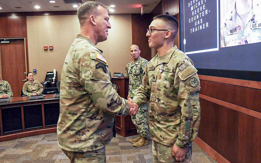 Gen. Michael “Erik” Kurilla, commander of Central Command, presents Sgt. Mickey Reeve with a medal for his contest-winning idea in a ceremony at MacDill Air Force Base in Tampa, Fla., on Oct. 14, 2022. Reeve received the Defense Meritorious Service Medal for his idea of building a simulator to help soldiers train on defending against drones while deployed.