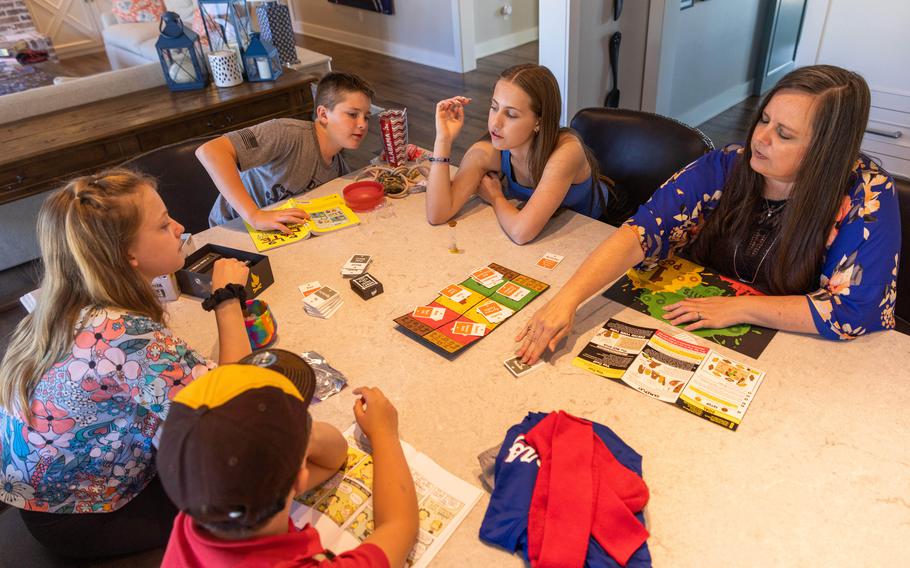 From left, Mary Virginia, Jack, Whitman, Annalise and mother Adriana Stacey play a game at their home in Fayetteville, Ark. 