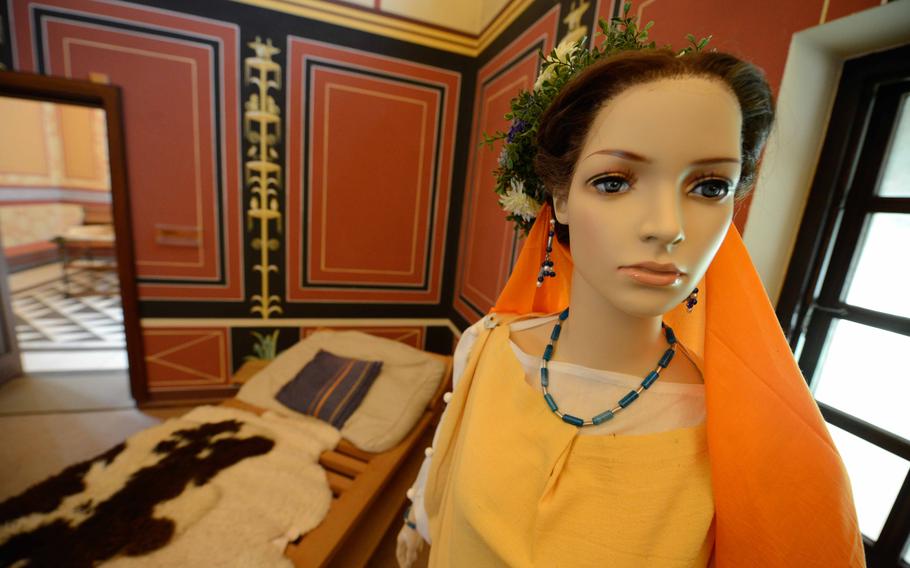 A mannequin dressed in authentic Roman attire showcases the fashionable hairstyles and clothing worn by gentry women during ancient times at Roman Villa Borg on May 2, 2023. The exhibit provides insight into the clothing and beauty standards of the Roman elite.