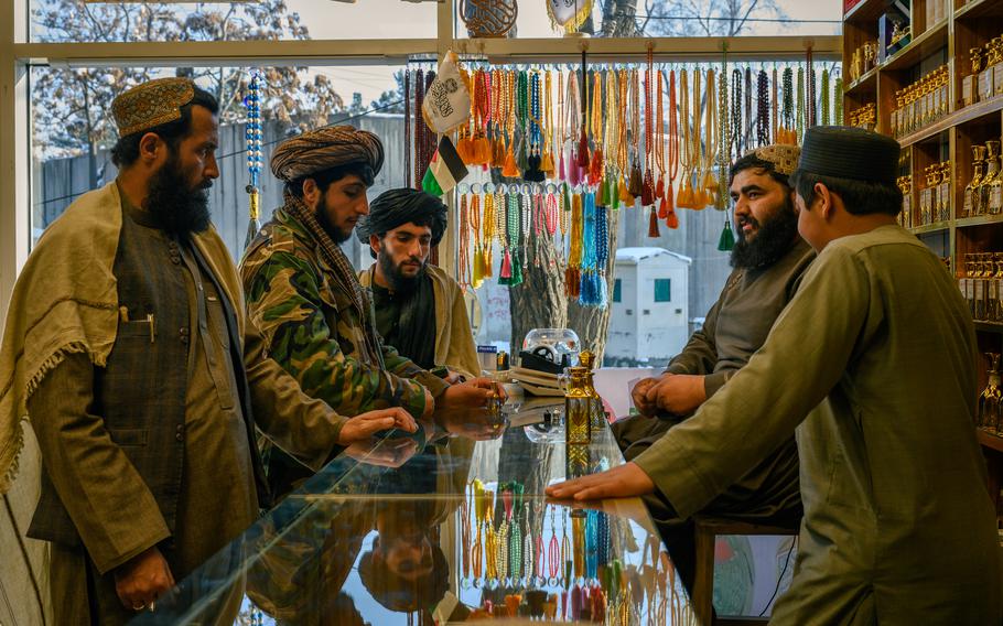 Former Taliban fighters look at perfume in a shop in central Kabul.