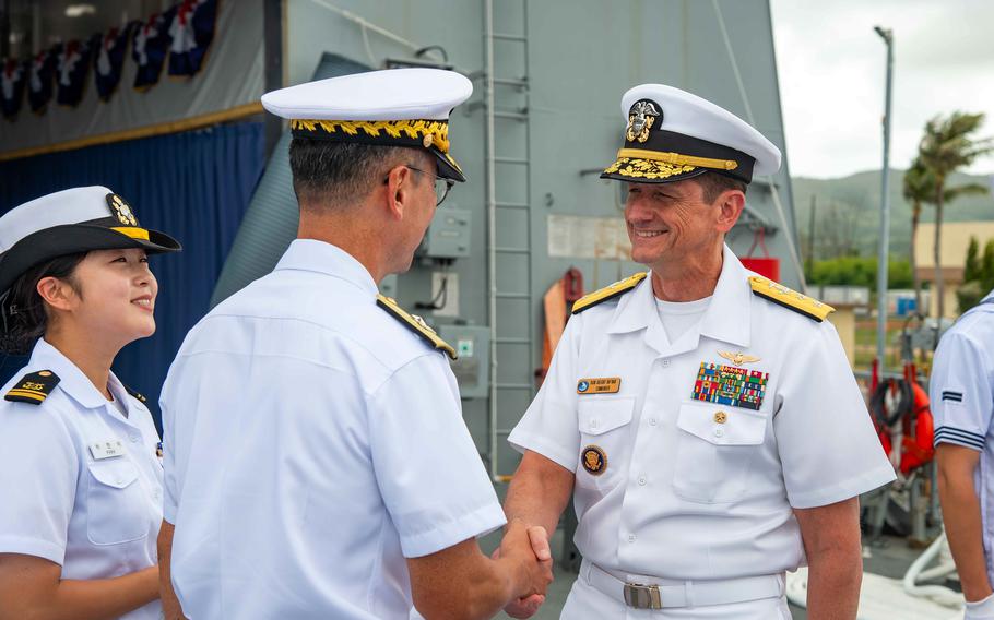 A rear admiral greets a South Korean counterpart.