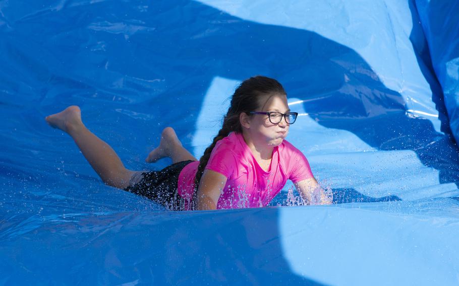 A girl slides down a waterslide.