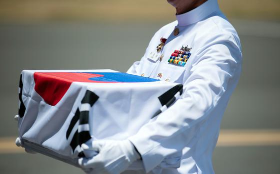 A South Korean sailor carries his uncle's remains during a Korean War remains repatriation ceremony at Joint Base Pearl Harbor-Hickam, Hawaii, July 25, 2023.