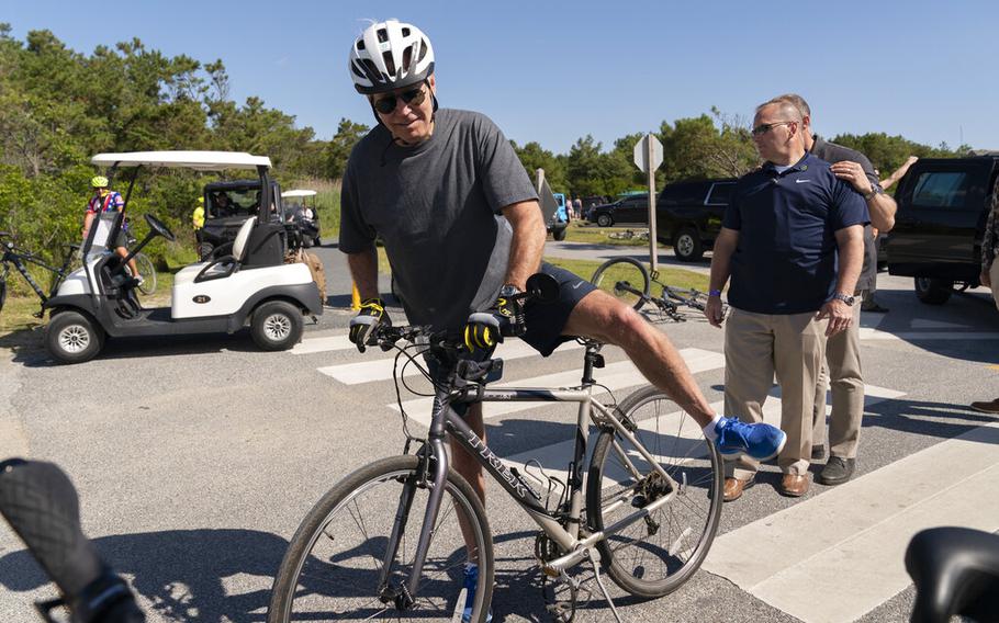 President Joe Biden gets back on his bike after he fell when he tried to get off his bike to greet a crowd at Gordons Pond in Rehoboth Beach, Del., Saturday, June 18, 2022.