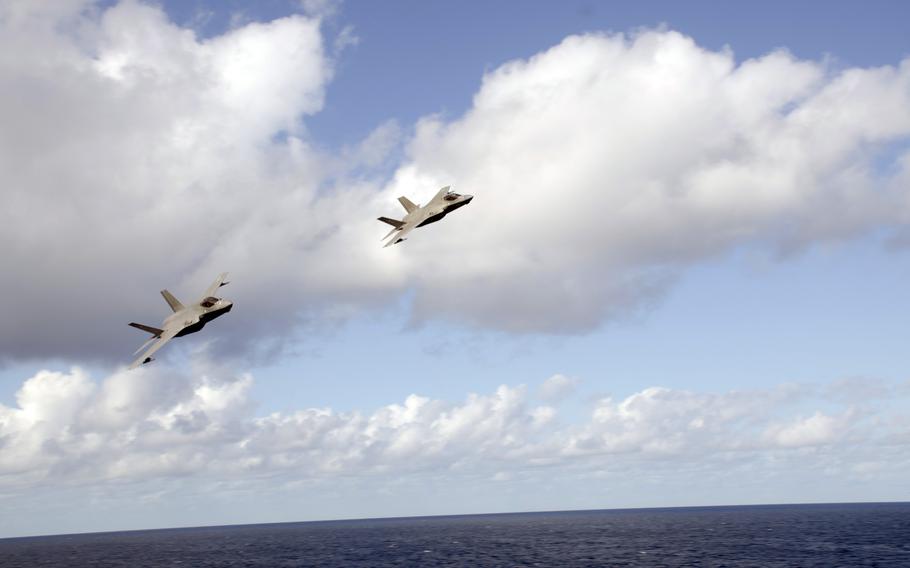 A pair of F-35C Lightning II stealth fighters fly by the aircraft carrier USS Carl Vinson in the Philippine Sea, Tuesday, Nov. 30, 2021. 