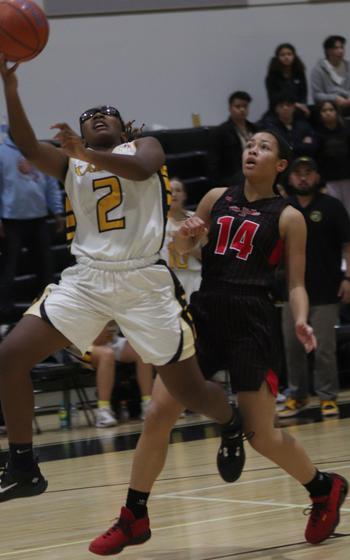 Kadena's Destiny Richardson drives past Kinnick's Naima Mincey in the girls D-I final.