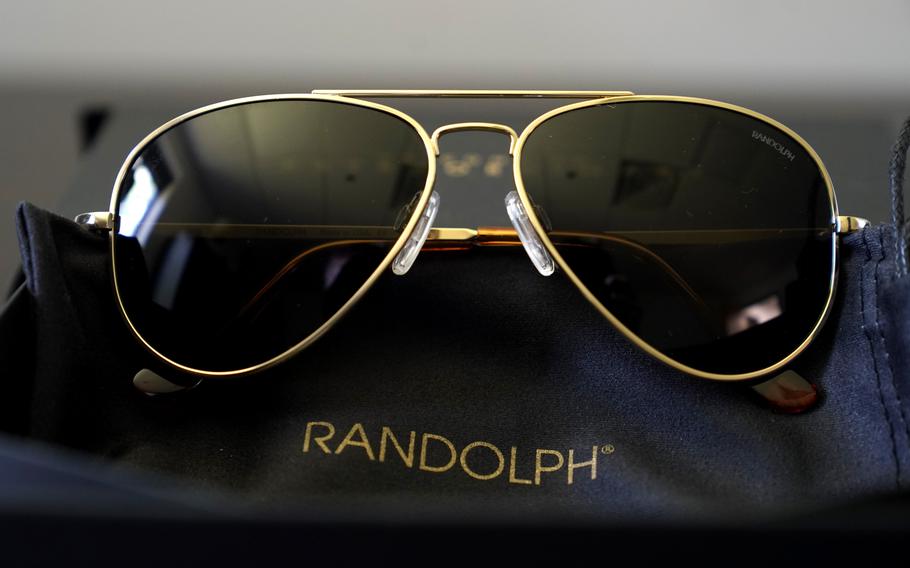 A pair of Randolph Engineering Concorde teardrop sunglasses, in 23-karat gold finish with polarized American gray lenses, rest on a table at the company where they are made, in Randolph, Mass., Thursday, June 17, 2021. 