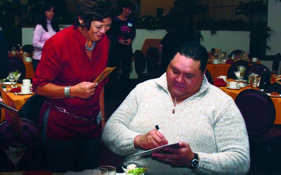 Chad Rowan, better known as legendary sumo wrestler Akebono, signs an autograph after speaking about sumo at the Officers' Club on Yokota Air Base, Japan, Nov. 6, 2007.