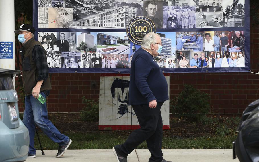 People pass a banner announcing the 100th anniversary outside Hines VA Hospital in Maywood Oct. 21, 2021.