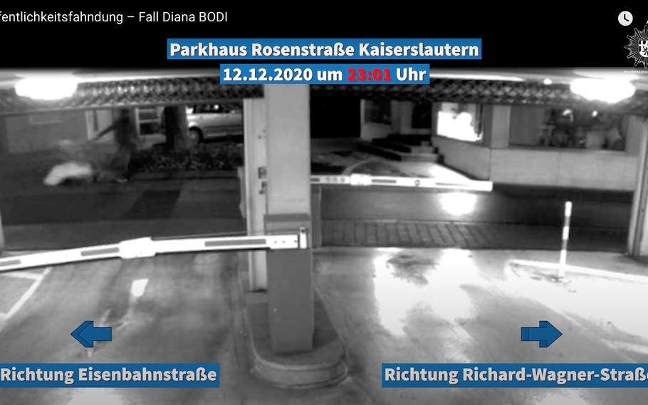 A screenshot from a video released by the German police July 22, 2021, shows a man pulling a shopping cart with a large object wrapped in white past a downtown Kaiserslautern parking garage last December. The man is a suspect in the death of Hungarian home care provider Diana Bodi, whose body was found in a nearby alley days after the video was shot.