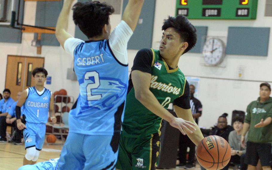 Daegu's Adrian Tagalog looks to pass against Osan's M.J. Siebert during Saturday's Korea boys basketball game. The Warriors won 68-61.