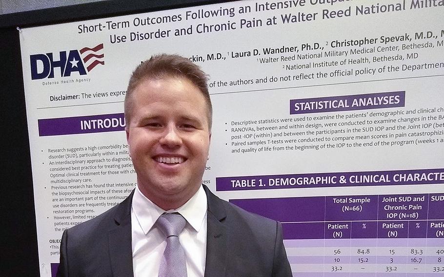 Dr. Michael Stockin stands in front of a Defense Health Agency display board during a 2019 event.