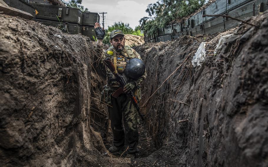 A Ukrainian soldier in a trench reacts as Russian shelling hits near their position in the Donetsk Region on June 1, 2022.