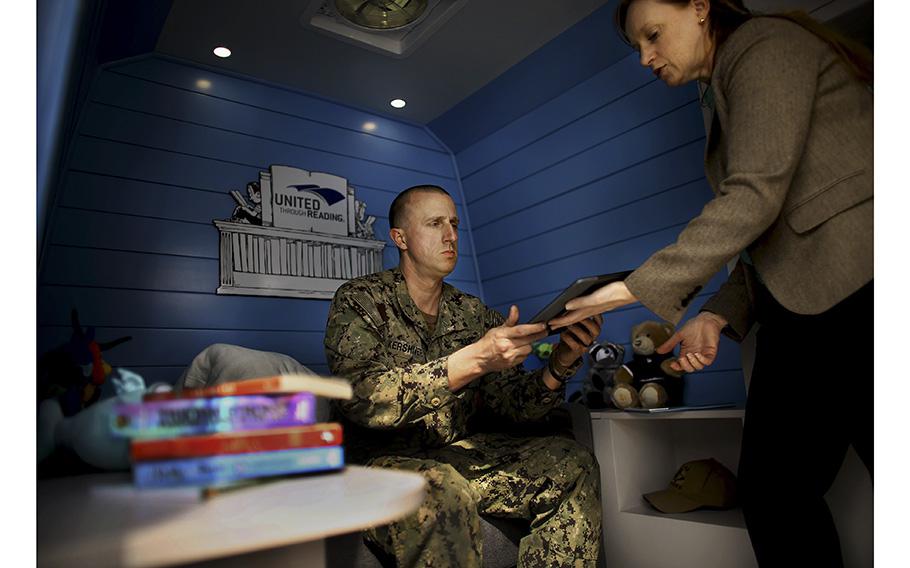 Lauren Steiner, program manager, prepares P.O. 2nd Class Tim Kershner to read a story for his children Friday, March 31, 2023, afternoon. The United Through Reading van regularly stops at the Armed Services YMCA in Virginia Beach.