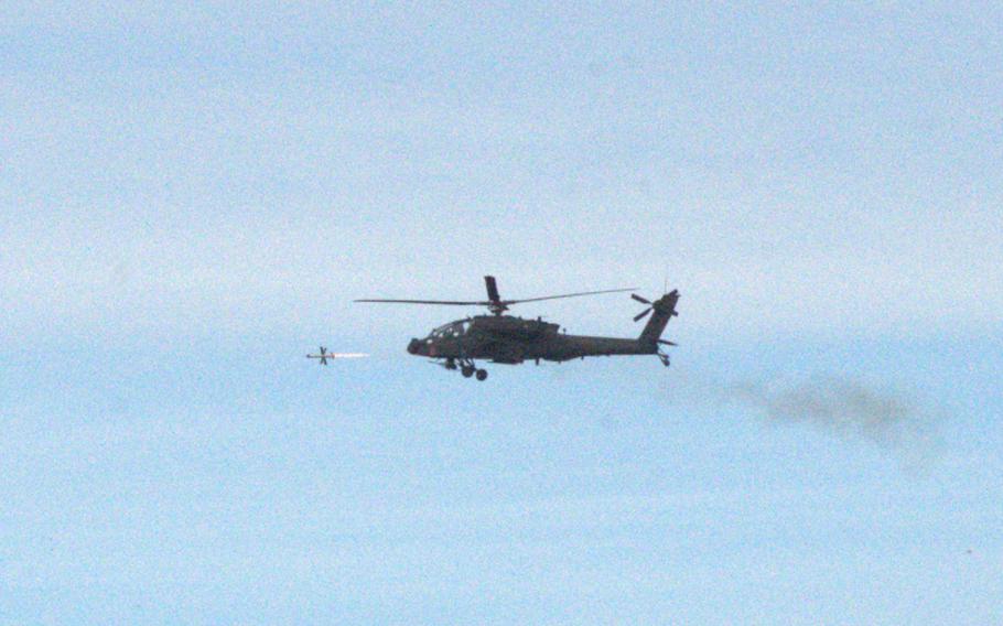 An Army AH-64E Apache helicopter fires a Spike Non-Line of Sight missile.