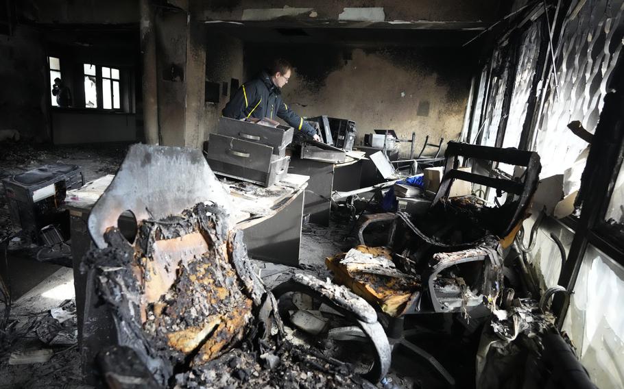 Maxim Kozlov, a journalist of the Mir broadcaster, funded by several former Soviet states, looks at aftermath of fire inside their burnt building in Almaty, Kazakhstan, Thursday, Jan. 13, 2022. 