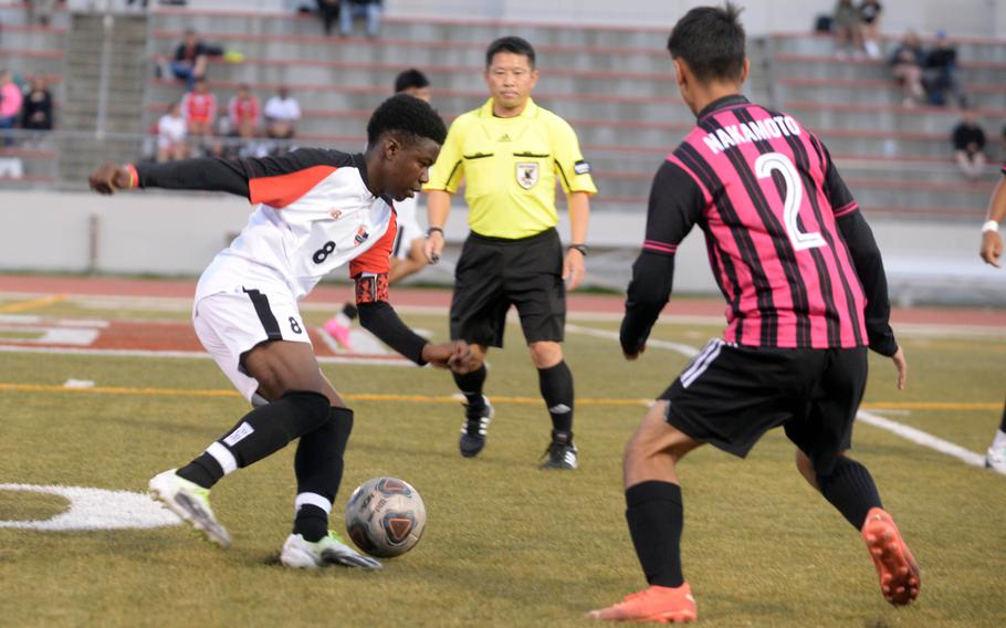 Nile C. Kinnick's Leon Awesso looks to move around Kadena's Alberto Nakamoto during Friday's DODEA interdistrict boys soccer match. The Panthers won 2-0 in a rematch of last April's Far East Division 1 final, won by the Red Devils at Kinnick 3-2.