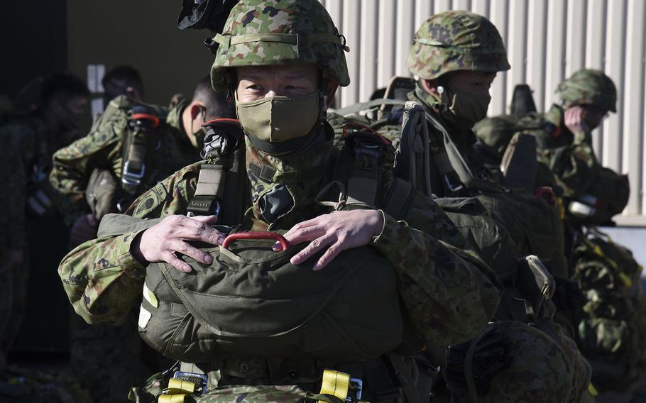 Troops from the Japan Ground Self-Defense Force prepare their parachuting gear at Yokota Air Base, Japan, ahead of jump on Thursday, Jan. 13, 2022.