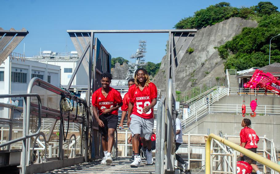 Members of the Nile C. Kinnick High School football team come aboard the aircraft carrier USS Ronald Reagan at Yokosuka Naval Base, Japan, Tuesday, Sept. 12, 2023.