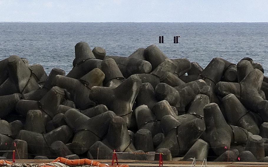 This photo taken during a visit by Associated Press journalists to the tsunami-wrecked Fukushima Daiichi nuclear power plant, four pillars are seen as an indicated point on Feb. 22, 2023, off the coast along the power plant, where an undersea tunnel through which the treated radioactive wastewater is released into sea is being constructed.