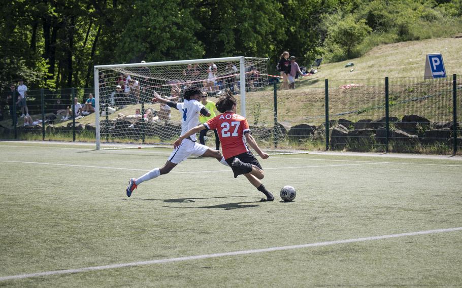 Gabriele Urbinate, a sophomore with the American Overseas School of Rome Falcons, takes a shot on goal while pressured by Rota Admirals center back Eyasu Selam during the Division II DODEA European Championships at Reichenbach-Steegen, Germany on May 20, 2025.