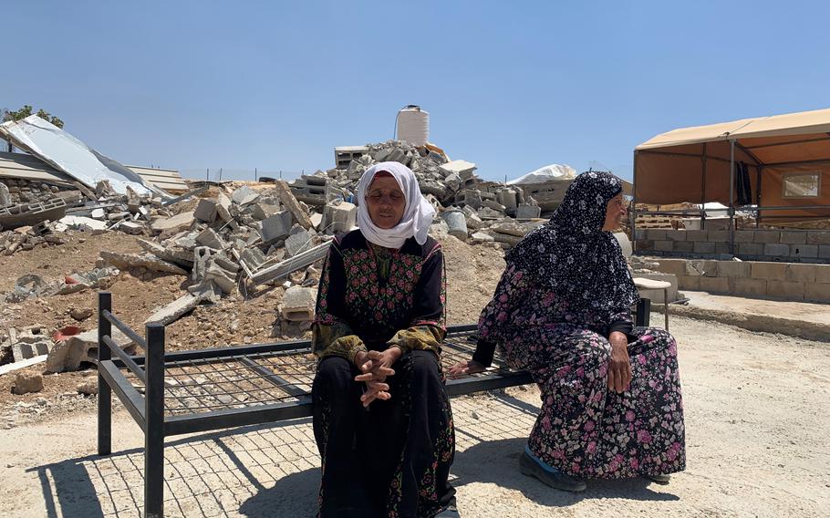 Safa Muhammed Aba al Najar, left, and Yusara al Najar sit on a bed frame in front of their house in the Masafer Yatta area of the West Bank that was demolished by the Israeli Army on May 11. 