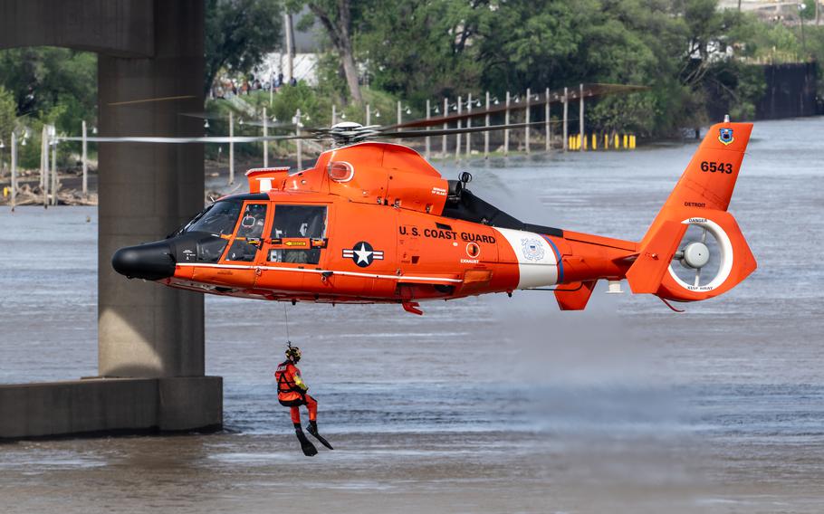 A U.S. Coast Guard rescue swimmer is lowered into the Ohio River as part of a helocast water-rescue demonstration during the Thunder Over Louisville air show in Louisville, Ky., Saturday, April 20, 2024.