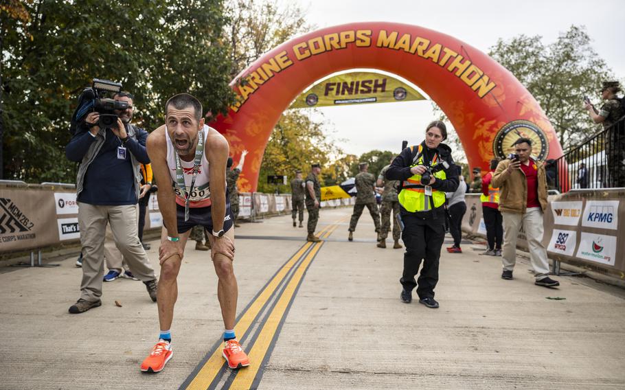 Calum Neff bends down to catch his breath after crossing the finish line