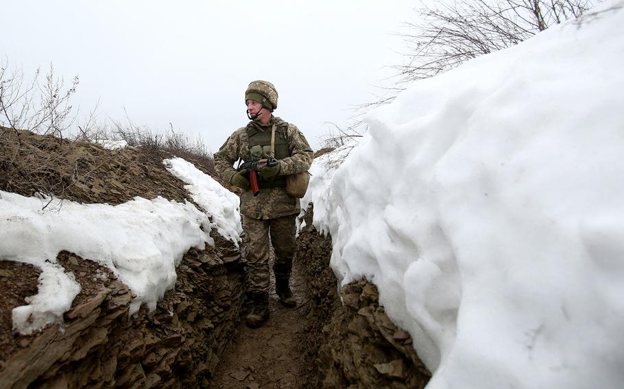An Ukrainian Military Forces serviceman walks on a trench on the frontline with Russia-backed separatists near Luganske village, in Donetsk region on Jan. 11, 2022.