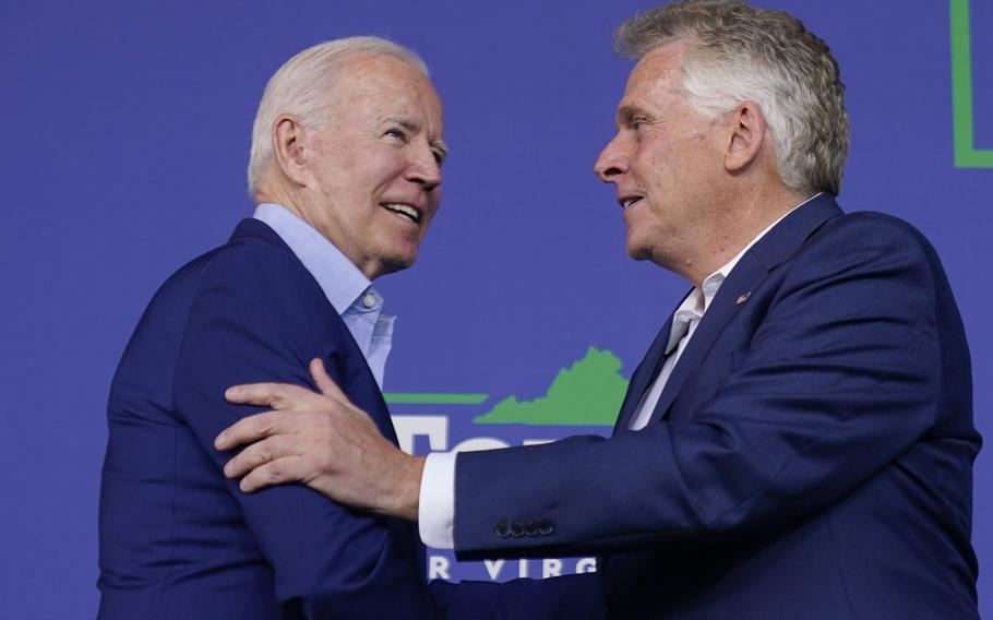 President Joe Biden greets Virginia democratic gubernatorial candidate Terry McAuliffe as he arrives to speak at a campaign event for McAuliffe at Lubber Run Park July 23 in Arlington, Va. 