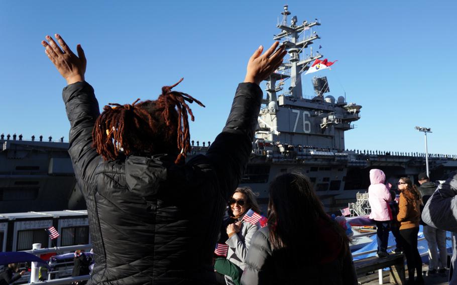 Sailors' family members cheer as the aircraft carrier USS Ronald Reagan returns to Yokosuka Naval Base, Japan, Friday, Dec. 16, 2022.