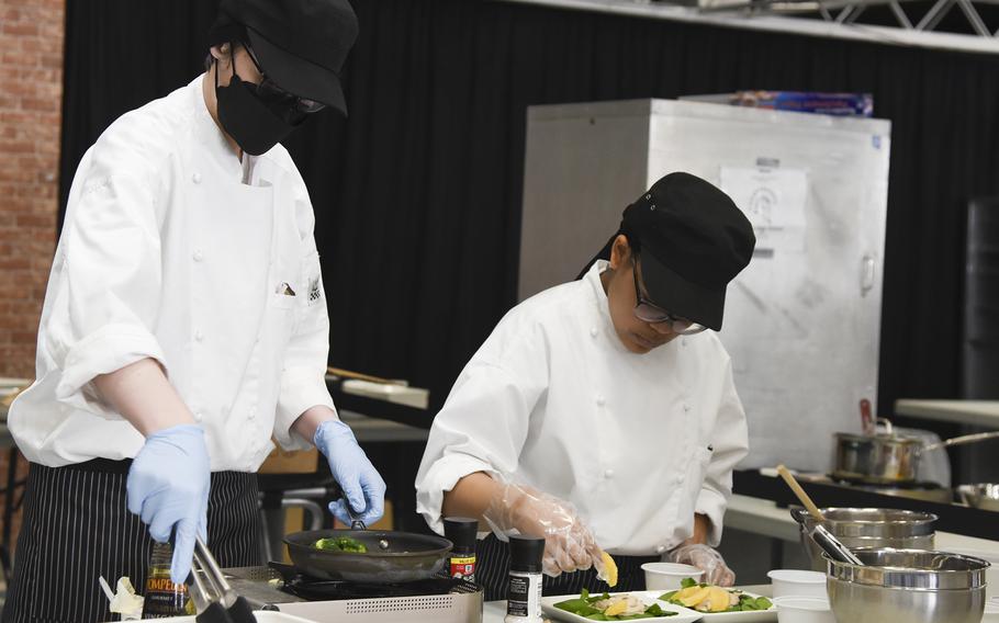 Humphreys High School students Emily Kieser, left, and Charleisha Sherlock prepare a dish during the Far East Culinary Arts Competition at Yokota Air Base, Japan, Feb. 7, 2023.